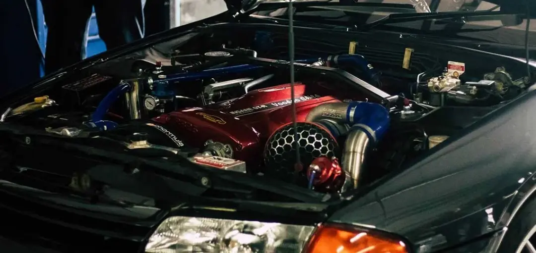 Turbocharged engine bay with a red cam cover
